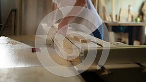 Carpenter using table saw to cut wooden boards