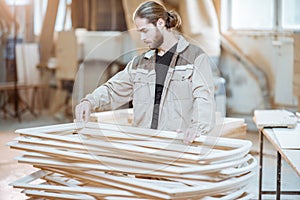 Carpenter with window frame at the workshop