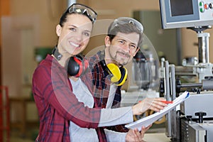 carpenter woman and man with drill in workshop