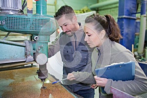 carpenter woman and man with drill in workshop