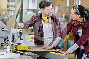 carpenter woman and man with drill in workshop