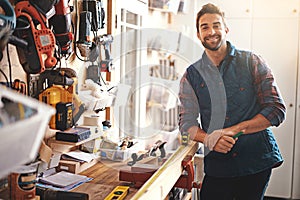 Carpenter, wood and portrait of happy man in workshop for home development, diy tools and building renovation. Smiling