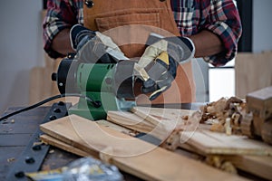 Carpenter on woodworking machines in carpentry shop, wooden product