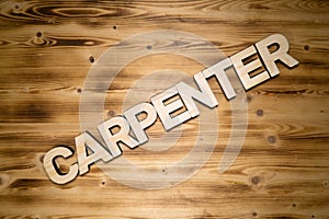 CARPENTER word made of wooden block letters on wooden board