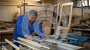 Carpenter at work at his workshop, wood processing on a woodworking machine