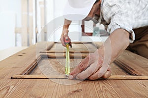 carpenter work the wood, measuring with meter tape a wooden vintage door