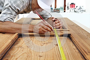 carpenter work the wood, measuring with meter tape a wooden vintage door