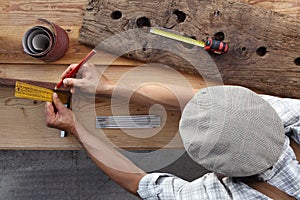 Carpenter work the wood, measuring with setsquare and pencil old