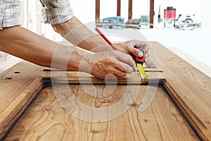 Carpenter work the wood, measuring a wooden vintage door