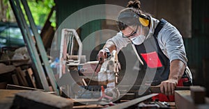 Carpenter work in wood workshop cutting wood piece with circular saw