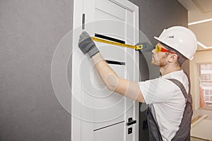 Carpenter worker installation process of measures cloth with ruler door hinge