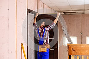 Carpenter worker installation process of measures cloth with ruler door hinge