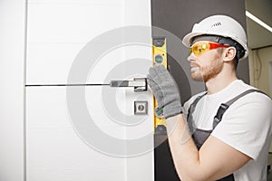 Carpenter worker installation process of wood door hinge tool level