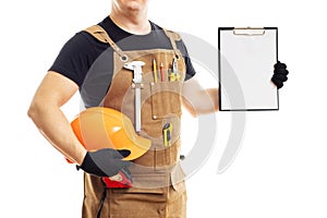 Carpenter in workers apron showing blank clipboard on white background