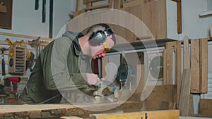 The carpenter is working. Carpenter cuts a board with a circular saw. Carpentry.