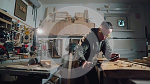 Carpenter working. Carpenter man in a carpentry workshop processes wood.