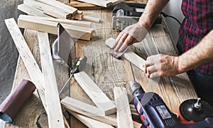 Carpenter working carpentry workshop Man sanding manually plank