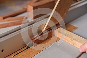 Carpenter working with circular saw helping with stick for safety