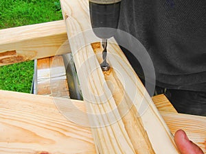 Carpenter working, drill, and wood timber construction woodwork workbench background in carpentry