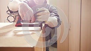 Carpenter working with an electric industrial stapler on the factory, fixing furniture details