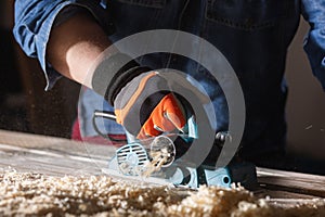 Carpenter working with electric planer