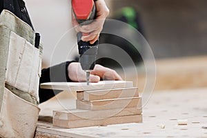 Carpenter working with an electric screwdriver on the work bench.