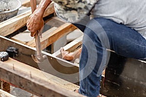 Carpenter working with hammer and meter on construction