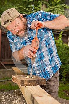 Carpenter working by hand drill