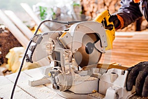 Carpenter working. Man cutting plank by circular saw.