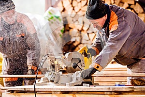 Carpenter working. Man cutting plank by circular saw.