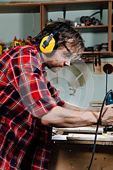 Carpenter working of manual hand milling machine in the carpentry workshop. joiner.