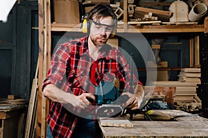 Carpenter working of manual hand milling machine in the carpentry workshop. joiner.