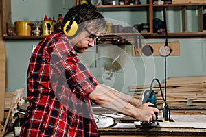 Carpenter working of manual hand milling machine in the carpentry workshop. joiner.