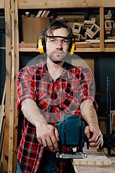 Carpenter working of manual hand milling machine in the carpentry workshop. joiner.