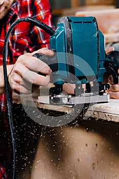 Carpenter working of manual hand milling machine in the carpentry workshop. joiner.