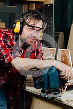 Carpenter working of manual hand milling machine in the carpentry workshop. joiner.