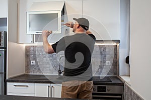 Carpenter working on new kitchen. Handyman fixing a door in a kitchen