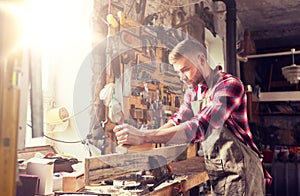 Carpenter working with plane and wood at workshop