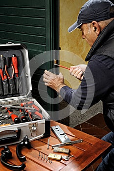 Carpenter working the replacement of the lock of a door.