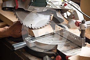 Carpenter working on sawing a board a circulation saw