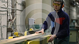 Carpenter working on sawing table in workshop