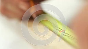 Carpenter working with tape measure,marking wooden desk