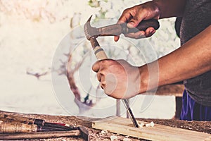 Carpenter working using a chisel is carving wood using a woodworking tool working in workshop