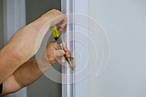 Carpenter working using a chisel with hole wooden door on a lock is installing the doors