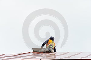 A carpenter is working on a wooden roof structure at a construction site. Industrial roofing system with wooden beams, beams and