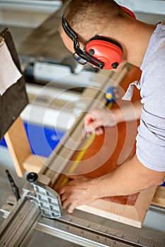 Carpenter working on woodworking machines in carpentry shop