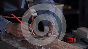 Carpenter working on woodworking machines in carpentry shop