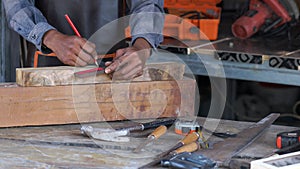 Carpenter working on woodworking machines in carpentry shop