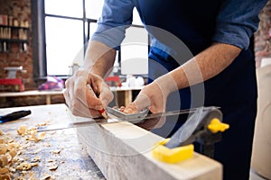 Carpenter working on woodworking machines in carpentry shop. A man works in a carpentry shop.