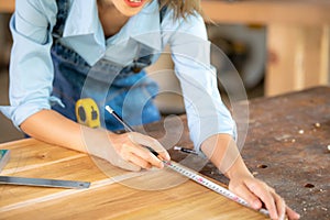 Carpenter working on woodworking machines in carpentry shop. woman works in a carpentry shop